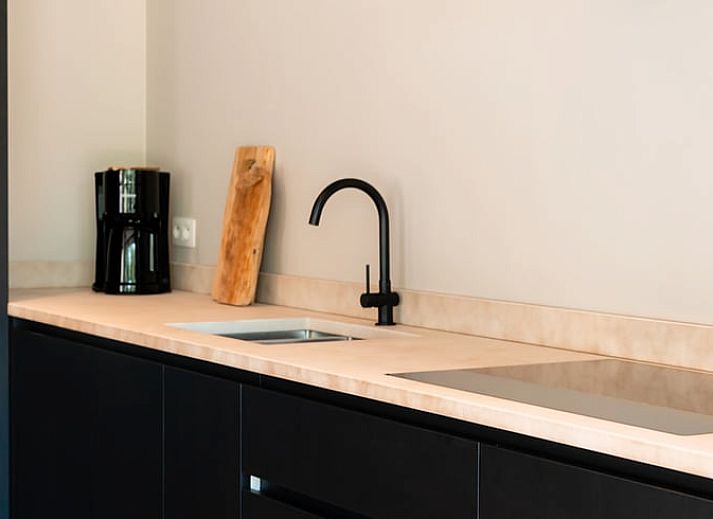 Ferienhaus in Westouter, Westflandern, Belgien, mit einer charmanten Backsteinmauer und einem Schild fuer einen einladenden Aufenthalt.