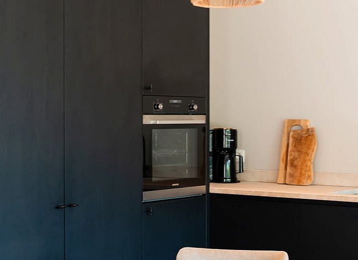 Ferienhaus in Westouter, Westflandern, Belgien, mit einer charmanten Backsteinmauer und einem Schild fuer einen einladenden Aufenthalt.