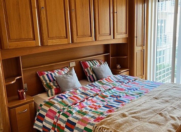 Gezellige woonkamer in DIOMAR appartement, De Haan, met comfortabel interieur en uitzicht op balkon.