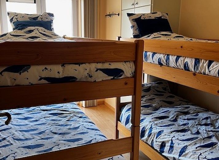 Gezellige woonkamer in DIOMAR appartement, De Haan, met comfortabel interieur en uitzicht op balkon.