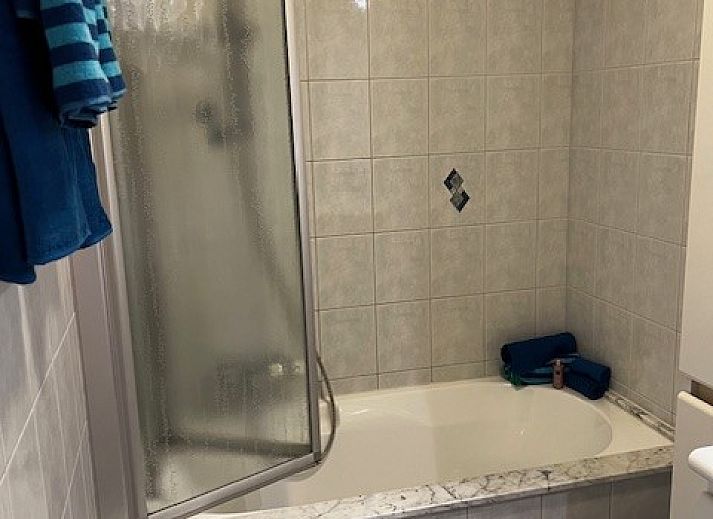 Gezellige woonkamer in DIOMAR appartement, De Haan, met comfortabel interieur en uitzicht op balkon.
