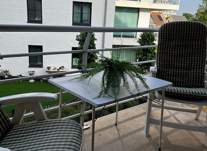 Gezellige woonkamer in DIOMAR appartement, De Haan, met comfortabel interieur en uitzicht op balkon.