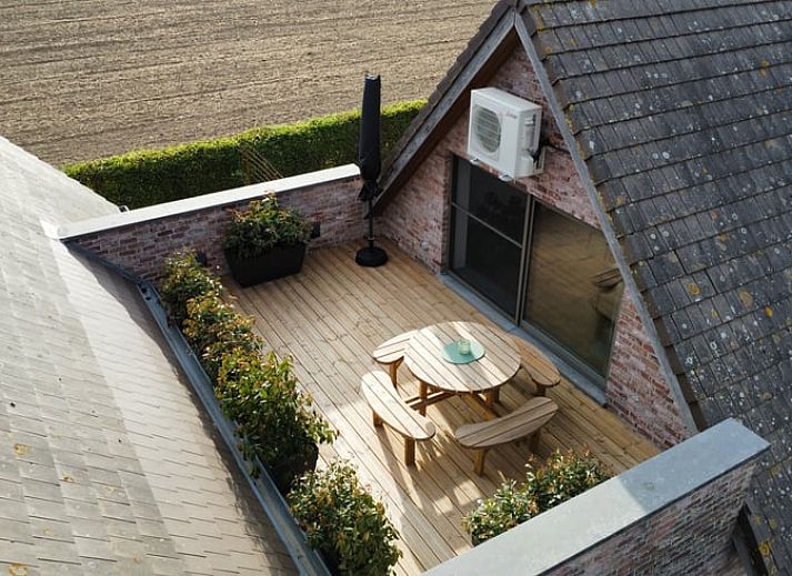 Geniessen Sie die Aussicht auf die gruene Landschaft von der Terrasse des Ferienhauses in PROVEN, Westflandern, Belgien.