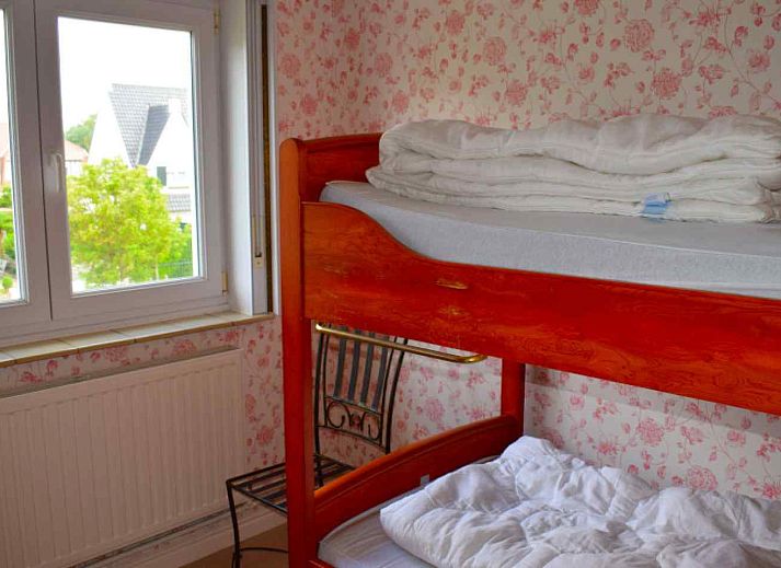 Front view of vacation home BK038 in Koksijde, West Flanders, with charming facade and green surroundings.