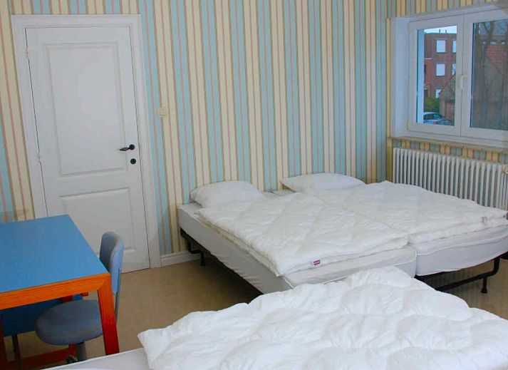 Cozy living room in vacation home BK038, Koksijde, West Flanders, with comfortable sitting area and warm furnishings.