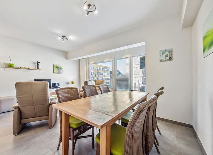 Gezellige eetruimte in vakantiehuis Azcona Twee, Koksijde, met een uitnodigende houten tafel en veel natuurlijk licht.