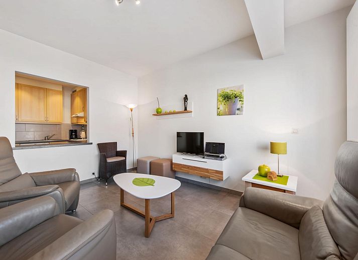 Gezellige eetruimte in vakantiehuis Azcona Twee, Koksijde, met een uitnodigende houten tafel en veel natuurlijk licht.