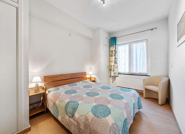 Gezellige eetruimte in vakantiehuis Azcona Twee, Koksijde, met een uitnodigende houten tafel en veel natuurlijk licht.