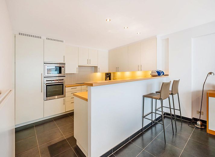 Spacious living room of Brit First vacation home in Koksijde, West Flanders, with modern furnishings and large windows for plenty of natural light.