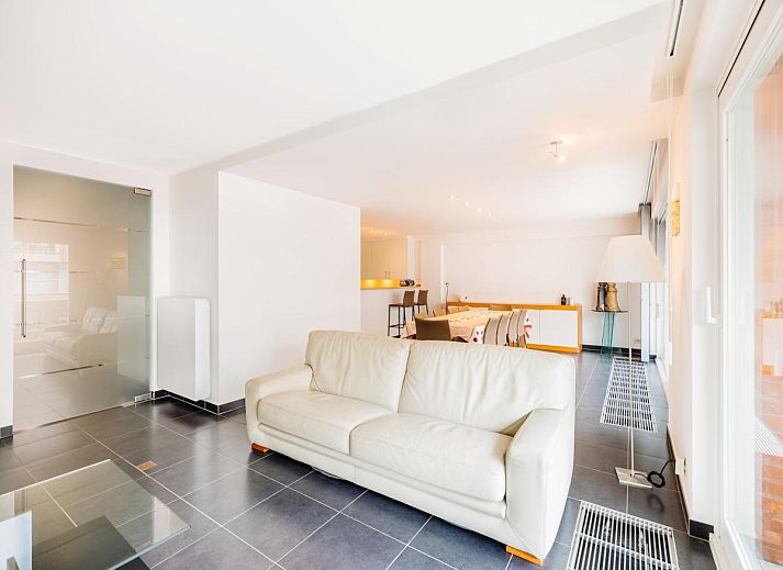 Spacious dining and living room of vacation home Brit First in Koksijde, West Flanders, with modern interior and city views.