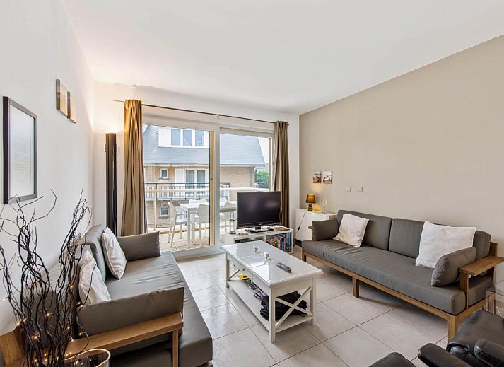 Gezellige woonkamer in Klokjesbloem Gelijkvloers vakantiehuis, Koksijde, Belgie, met uitzicht op het terras en veel natuurlijk licht.