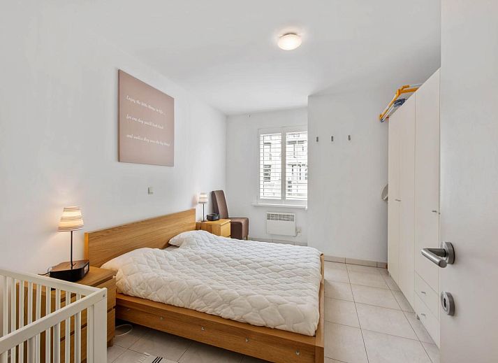 Gezellige woonkamer in Klokjesbloem Gelijkvloers vakantiehuis, Koksijde, Belgie, met uitzicht op het terras en veel natuurlijk licht.