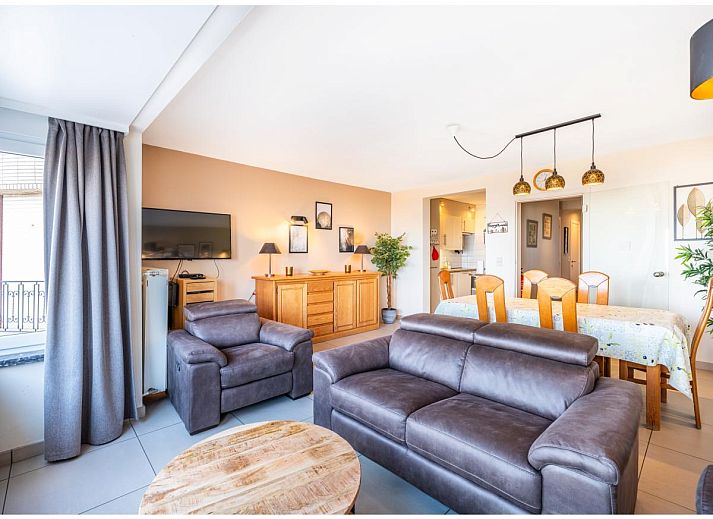Gezellige woonkamer van vakantiehuis Cortina tweede in Koksijde, West-Vlaanderen met comfortabele zithoek en eethoek voor een ontspannen verblijf.