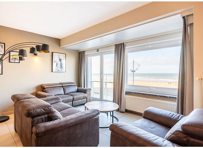 Gezellige woonkamer van vakantiehuis Cortina tweede in Koksijde, West-Vlaanderen met comfortabele zithoek en eethoek voor een ontspannen verblijf.
