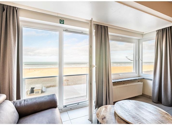 Gezellige woonkamer van vakantiehuis Cortina tweede in Koksijde, West-Vlaanderen met comfortabele zithoek en eethoek voor een ontspannen verblijf.