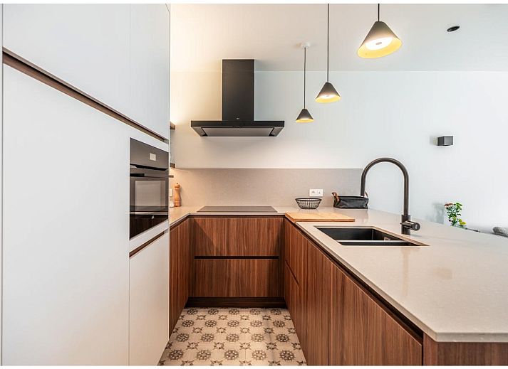 Stijlvolle woonkamer van La Balise Derde vakantiehuis in Koksijde, Belgie, met moderne keuken en comfortabele zithoek.
