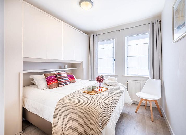 Lichte woonkamer van Gaston Lejeune tweede vakantiehuis in Koksijde, Belgie met moderne keuken en gezellig zitgedeelte.