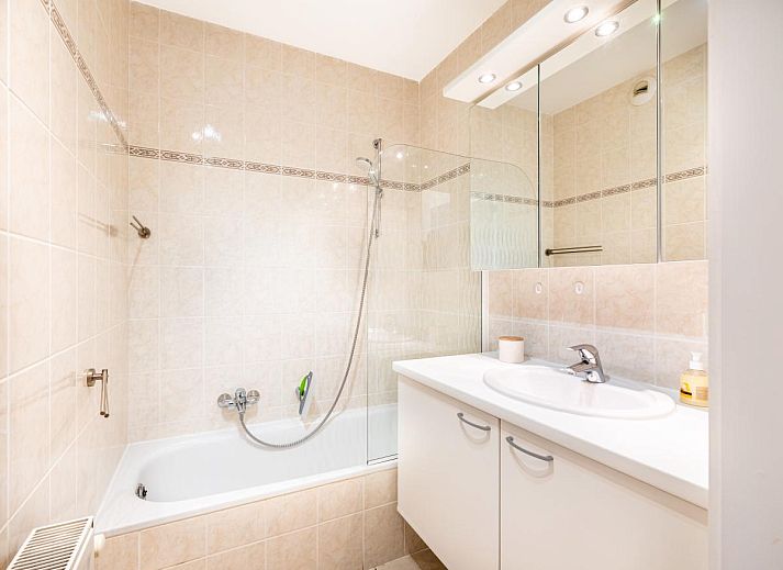 Gezellige woonkamer van Gaston Lejeune tweede vakantiehuis in Koksijde, West-Vlaanderen, met moderne keuken en comfortabele zithoek.