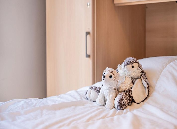 Modernes Wohnzimmer des Ferienhauses Guernsey second in Koksijde, Westflandern, Belgien mit offener Kueche und grosszuegigem Essbereich.