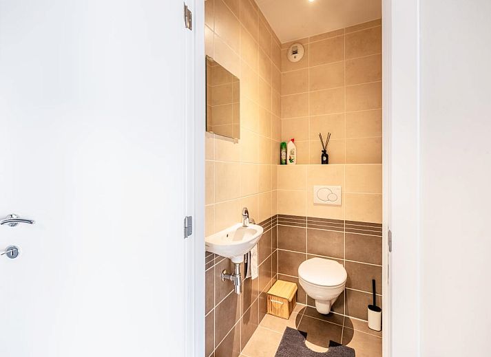Modernes Wohnzimmer des Ferienhauses Guernsey second in Koksijde, Westflandern, Belgien mit offener Kueche und grosszuegigem Essbereich.