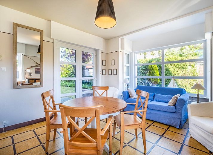 Gezellige woonkamer in Juvamy gelijkvloers vakantiehuis, Koksijde, met veel lichtinval en uitzicht op groene tuin, West-Vlaanderen, Belgie.