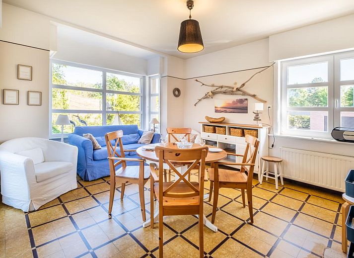 Gezellige woonkamer in Juvamy gelijkvloers vakantiehuis, Koksijde, met veel lichtinval en uitzicht op groene tuin, West-Vlaanderen, Belgie.