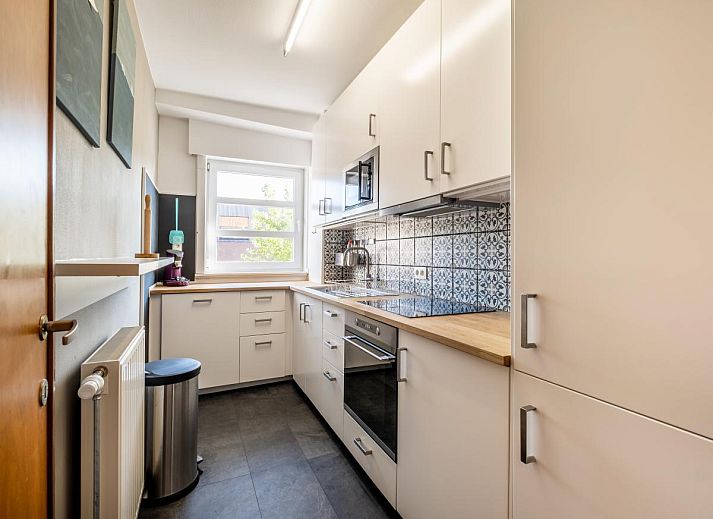 Gezellige woonkamer in Juvamy gelijkvloers vakantiehuis, Koksijde, met veel lichtinval en uitzicht op groene tuin, West-Vlaanderen, Belgie.
