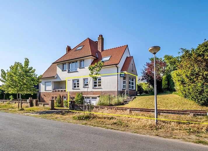 Gezellige woonkamer in Juvamy gelijkvloers vakantiehuis, Koksijde, met veel lichtinval en uitzicht op groene tuin, West-Vlaanderen, Belgie.