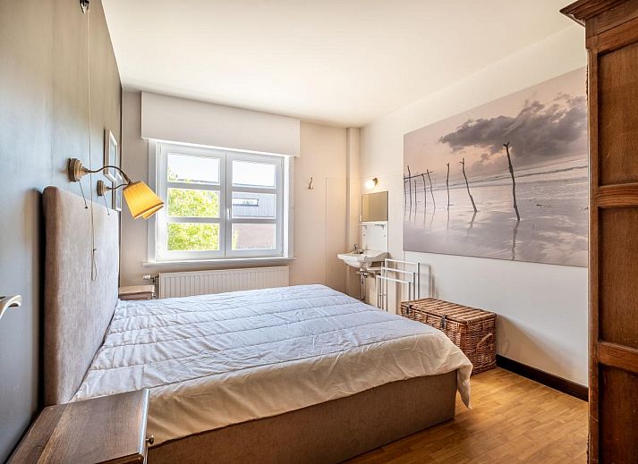 Gezellige woonkamer in Juvamy gelijkvloers vakantiehuis, Koksijde, met veel lichtinval en uitzicht op groene tuin, West-Vlaanderen, Belgie.