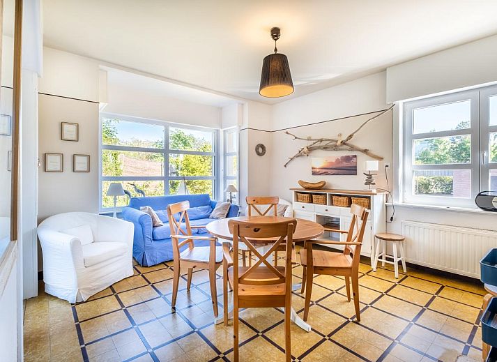 Gezellige eetkamer in Juvamy gelijkvloers, vakantiehuis in Koksijde, West-Vlaanderen, met veel licht en comfortabele zithoek.