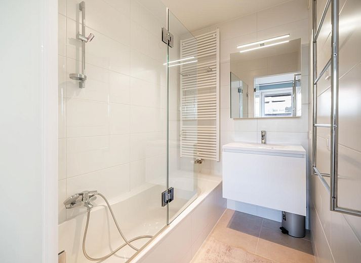 Lichte woonkamer van vakantiehuis De Dijk derde in Koksijde, West-Vlaanderen, met panoramisch uitzicht op het strand en de zee.