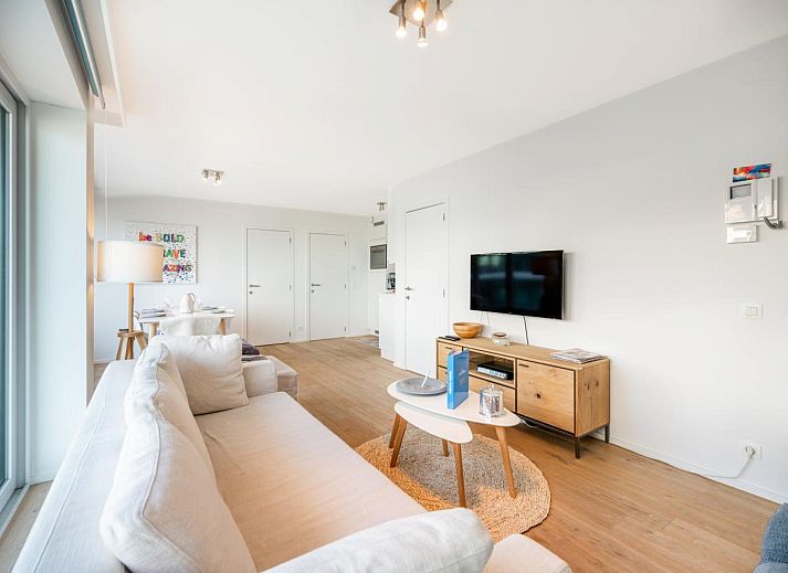 Lichte woonkamer van vakantiehuis De Dijk derde in Koksijde, West-Vlaanderen, met panoramisch uitzicht op het strand en de zee.