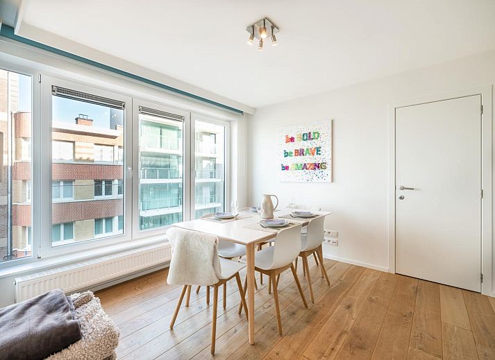 Lichte woonkamer van vakantiehuis De Dijk derde in Koksijde, West-Vlaanderen, met panoramisch uitzicht op het strand en de zee.