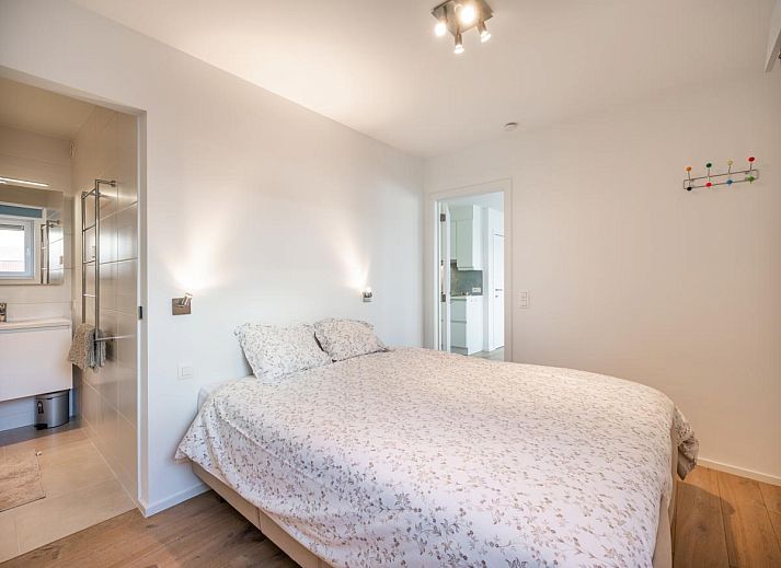 Lichte woonkamer van De Dijk derde vakantiehuis in Koksijde, West-Vlaanderen, met moderne inrichting en grote ramen voor een ruimtelijk gevoel.