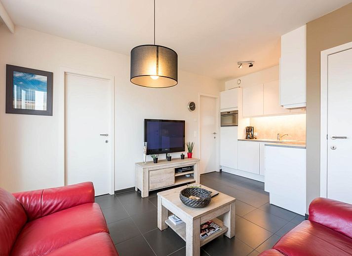 Gezellige woonkamer in vakantiehuis De Dijk zesde, Koksijde, met moderne inrichting en uitzicht op de stad West-Vlaanderen, Belgie.