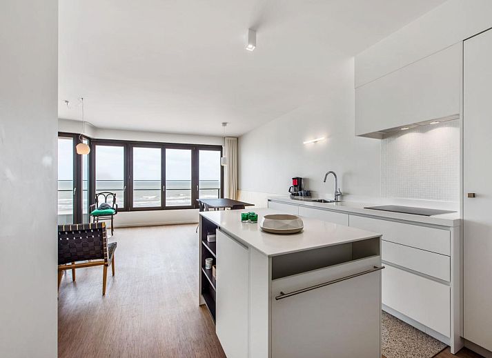 Ruime woonkamer van vakantiehuis De Meeuwen derde in Koksijde, Belgie, met panoramisch uitzicht op de kustlijn van West-Vlaanderen.