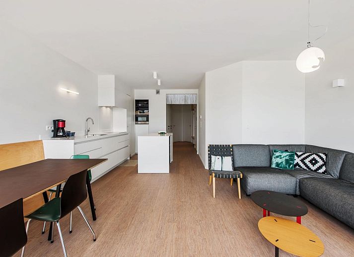 Lichte woonkamer in De Meeuwen derde vakantiehuis met zeezicht in Koksijde, West-Vlaanderen, Belgie.