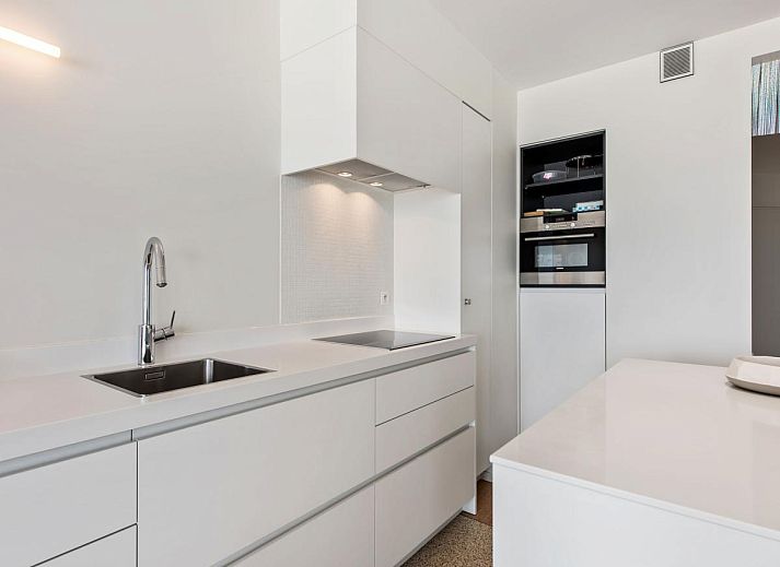 Lichte woonkamer in De Meeuwen derde vakantiehuis met zeezicht in Koksijde, West-Vlaanderen, Belgie.