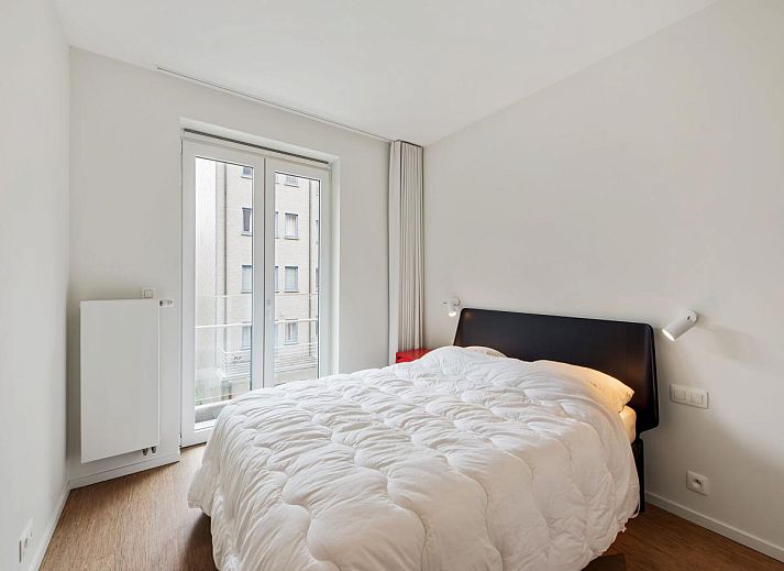 Lichte woonkamer in De Meeuwen derde vakantiehuis met zeezicht in Koksijde, West-Vlaanderen, Belgie.