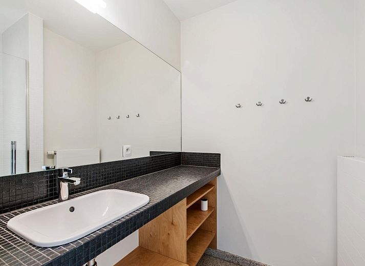 Lichte woonkamer in De Meeuwen derde vakantiehuis met zeezicht in Koksijde, West-Vlaanderen, Belgie.