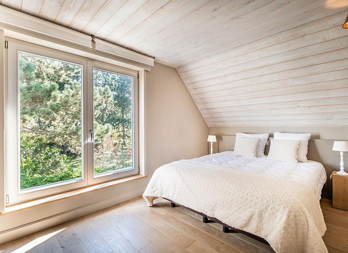 Lichte woonkamer van vakantiehuis Tranquil in Koksijde, West-Vlaanderen met uitzicht op zonnig terras en tuin.