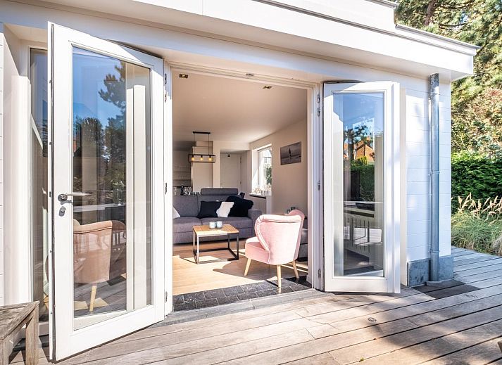 Lichte woonkamer van vakantiehuis Tranquil in Koksijde, West-Vlaanderen met uitzicht op zonnig terras en tuin.