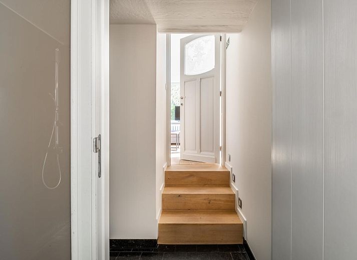 Lichte woonkamer van vakantiehuis Tranquil in Koksijde, West-Vlaanderen met uitzicht op zonnig terras en tuin.