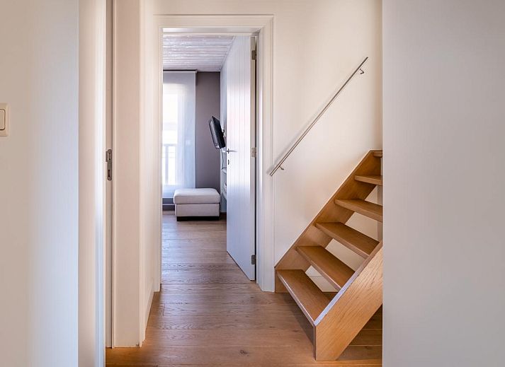 Lichte woonkamer van vakantiehuis Tranquil in Koksijde, West-Vlaanderen met uitzicht op zonnig terras en tuin.