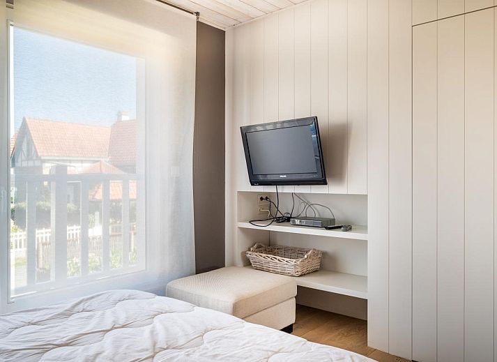 Geniet van de serene veranda bij vakantiehuis Tranquil in Koksijde, West-Vlaanderen, omgeven door groene natuur en rustgevende tuinen.