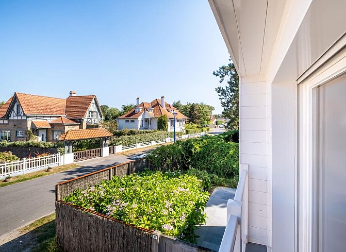 Geniet van de serene veranda bij vakantiehuis Tranquil in Koksijde, West-Vlaanderen, omgeven door groene natuur en rustgevende tuinen.