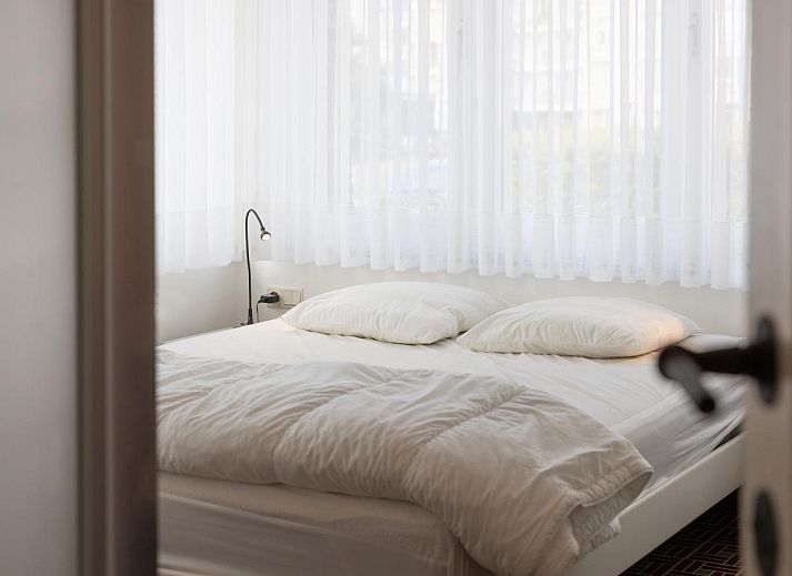 Gezellige woonkamer in vakantiehuis Porpoises, Koksijde, West-Vlaanderen, met comfortabele zithoek en sfeervolle open haard.
