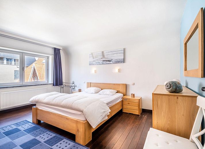 Lichte eetkamer in vakantiehuis Porpoises, Koksijde, met uitzicht op zonnig terras en tuin, ideaal voor een ontspannen verblijf in West-Vlaanderen.