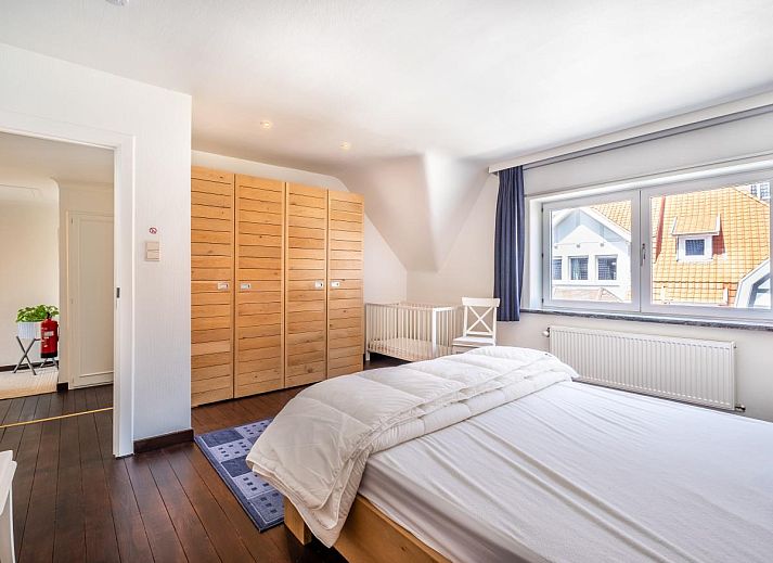 Lichte eetkamer in vakantiehuis Porpoises, Koksijde, met uitzicht op zonnig terras en tuin, ideaal voor een ontspannen verblijf in West-Vlaanderen.