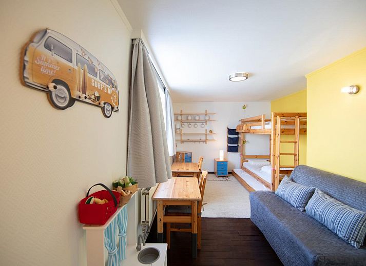 Lichte eetkamer in vakantiehuis Porpoises, Koksijde, met uitzicht op zonnig terras en tuin, ideaal voor een ontspannen verblijf in West-Vlaanderen.